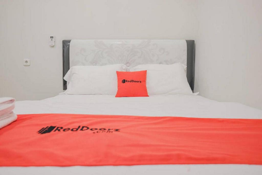 Postel nebo postele na pokoji v ubytování RedDoorz Plus near Soekarno Hatta Airport Taman Mahkota