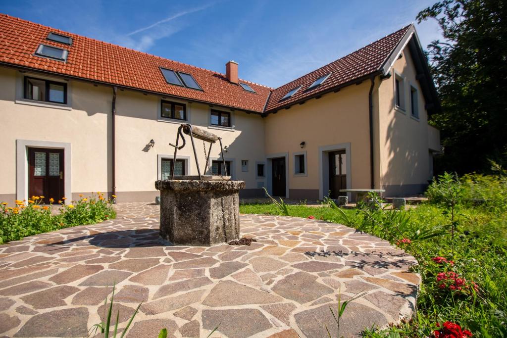 a house with a fountain in the yard at Holiday country house Gora in Gozd