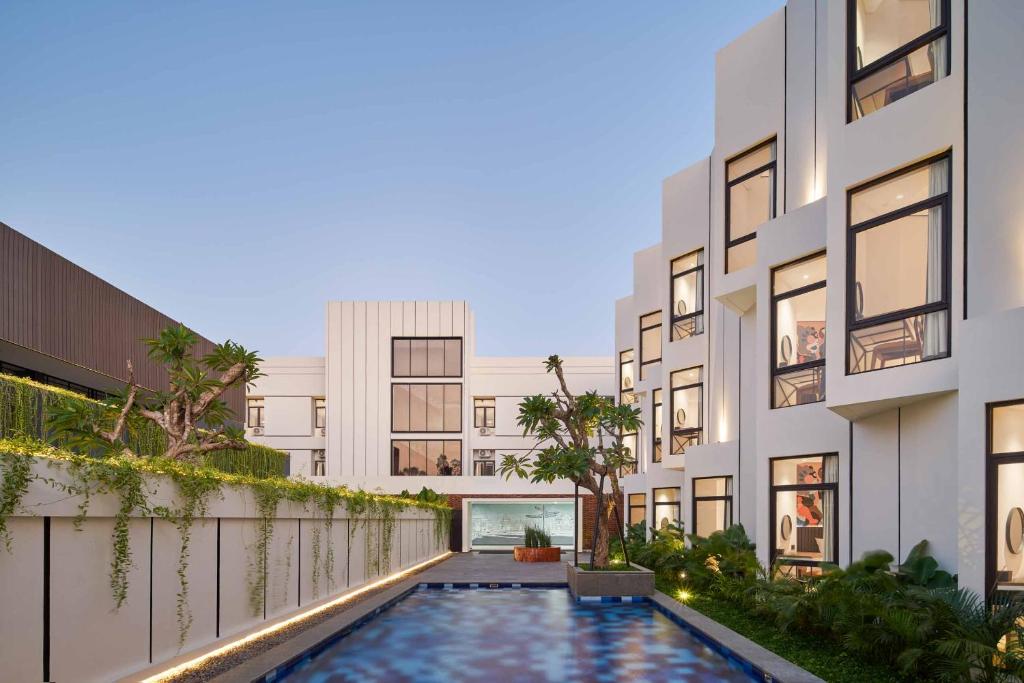 an exterior view of a building with a swimming pool at JW NAUNGAN COLIVING in Solo