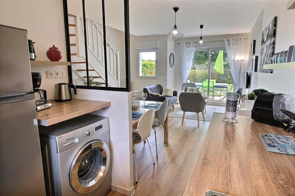 een keuken en een woonkamer met een wasmachine en droger bij Gite - Le Green - Maison avec Terrasse dans parc avec piscine proche plages et Golf in Pléneuf-Val-André