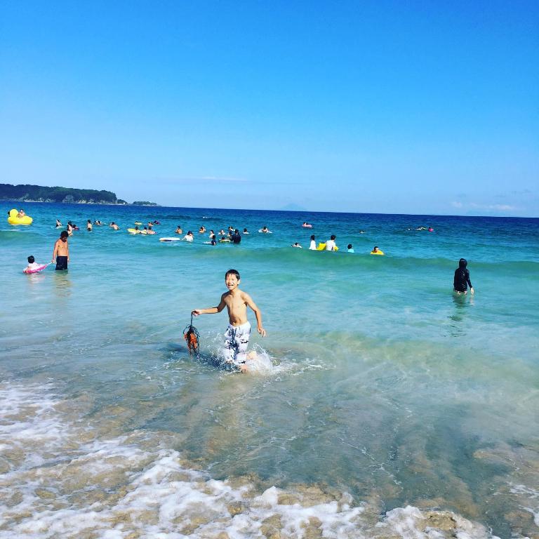 a young boy walking in the water at the beach at Toraya Attic in Shimoda
