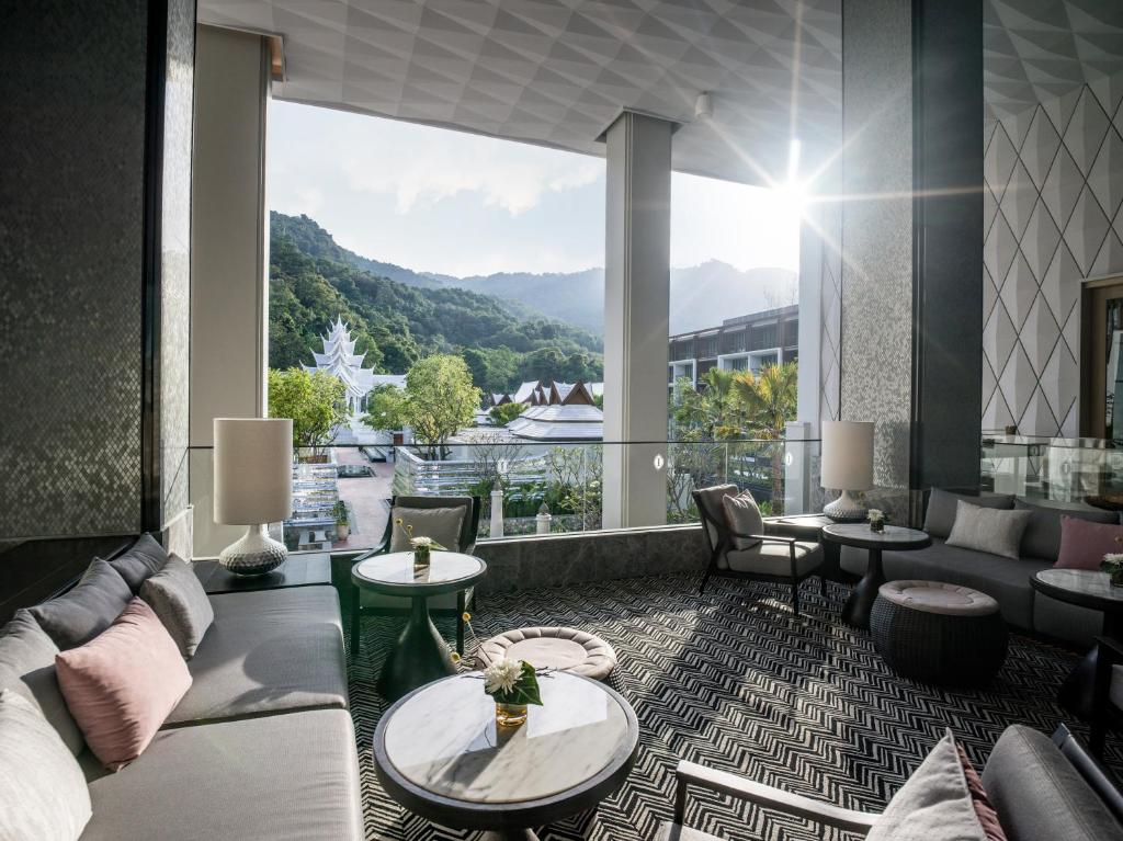 a living room with a couch and a large window at InterContinental Phuket Resort by IHG in Kamala Beach