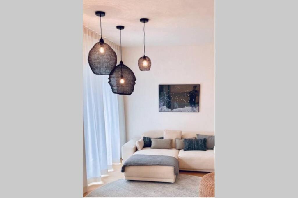 uma sala de estar com luzes pendentes e um sofá em Design-Ferienwohnung an der Madbachtalsperre em Rheinbach