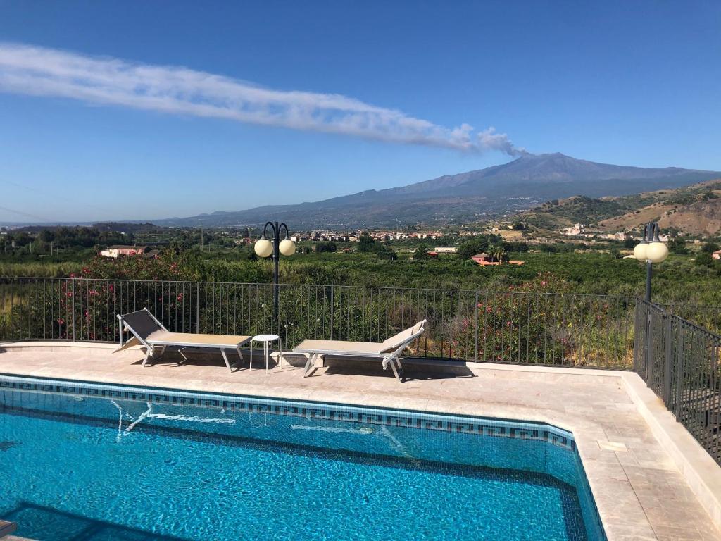 a swimming pool with two chairs and a fire truck at Villino Lenci in Trappitello
