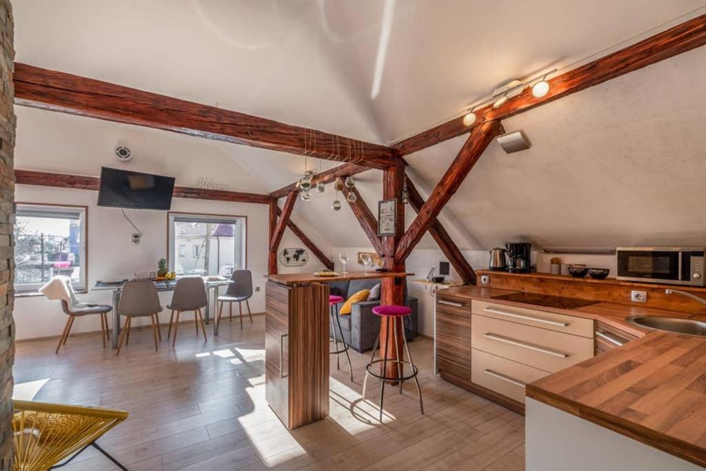 een keuken en eetkamer met houten balken bij LTE Apartments in Maribor