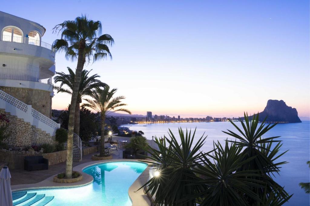 a swimming pool with a view of the water at Villa Primera Linea in Calpe