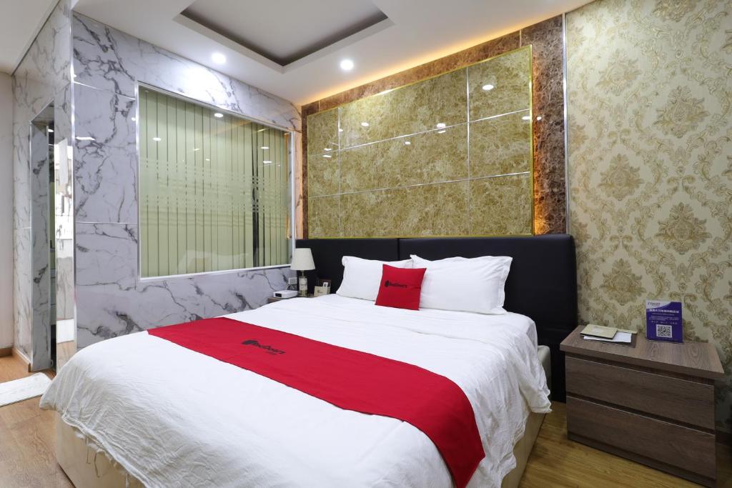 a bedroom with a large bed with a red blanket at Vienna Hotel in Ho Chi Minh City