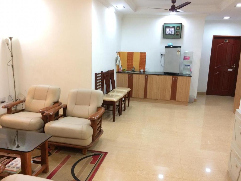 una sala de espera en una clínica con sillas y nevera en Swarna Sudarshan Service Apartment @ Adyar chennai en Chennai