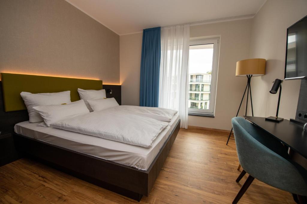 Postel nebo postele na pokoji v ubytování EINSTEIN Hotel am Römerpark
