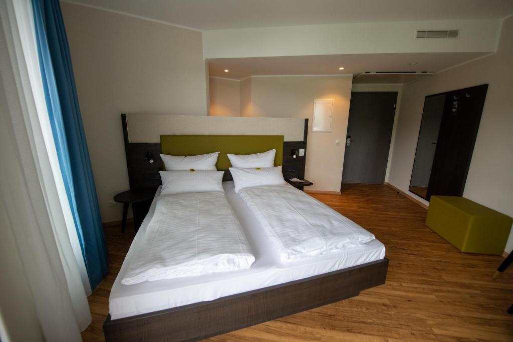 Postel nebo postele na pokoji v ubytování EINSTEIN Hotel am Römerpark