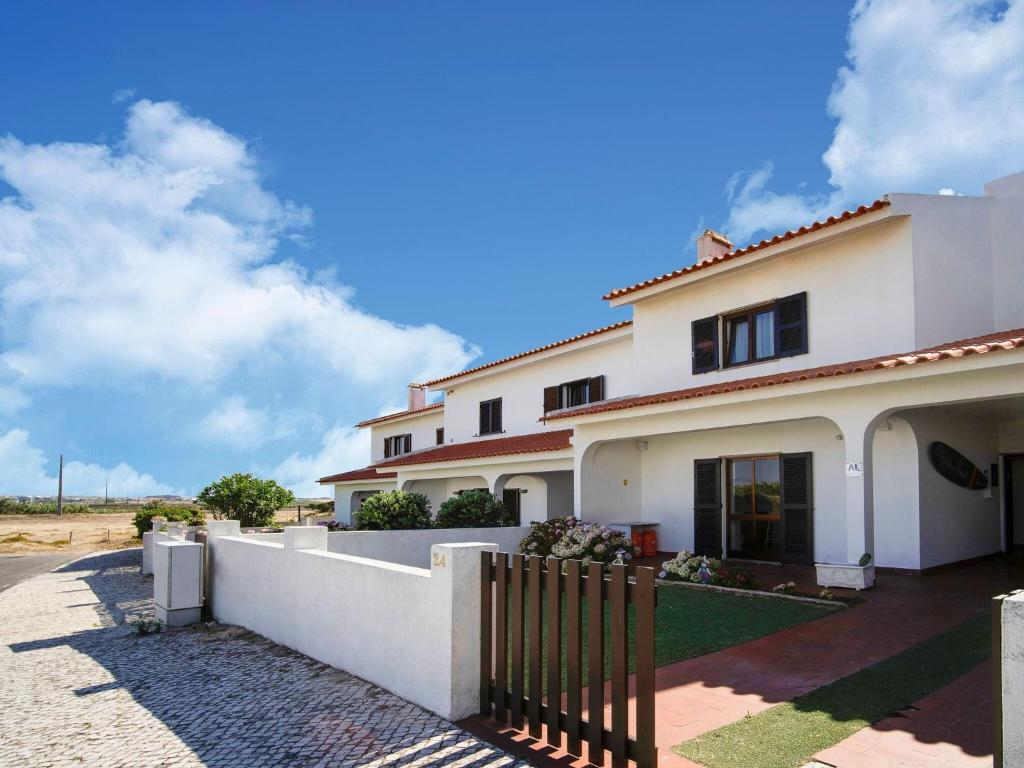 una casa blanca con una valla delante en Soothing Holiday Home in Ferrel near Baleal Island, en Ferrel