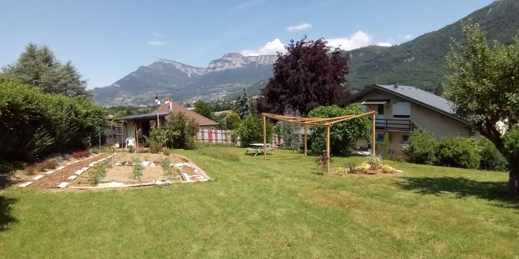 a backyard with a garden and mountains in the background at Zimmer mit Frühstück in Challes-les-Eaux