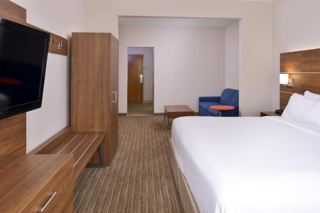 a hotel room with a bed and a flat screen tv at Holiday Inn Express & Suites Chattanooga - East Ridge by IHG in Chattanooga