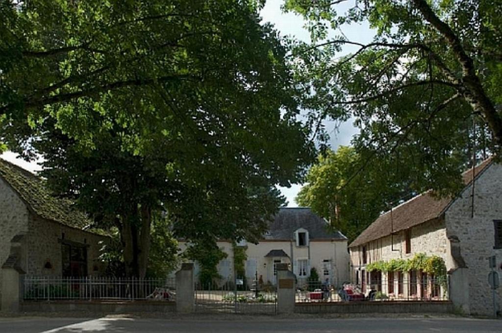 un groupe de maisons avec des arbres et une rue dans l'établissement Château de la Frégeolière, à Theillay