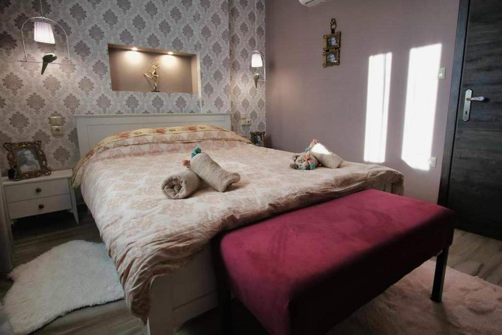 ein Schlafzimmer mit einem Bett mit zwei ausgestopften Tieren darauf in der Unterkunft Mama's Cozy Room 2 in Kalambaka