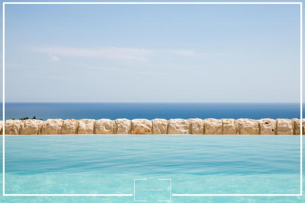 a painting of the ocean next to a stone wall at Villa Domus Petraianca in Marina di Ragusa