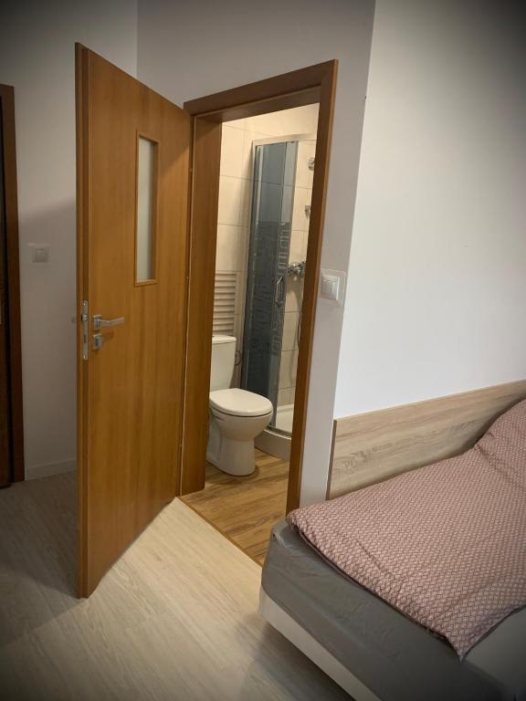 drzwi do łazienki z toaletą i łóżkiem w obiekcie Hostel Sportowa w mieście Płońsk