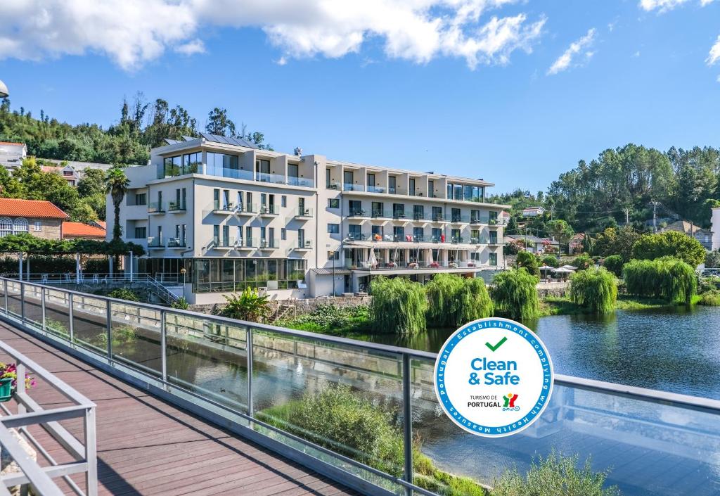 un hotel con una señal frente a un cuerpo de agua en Hotel Vouga, en Termas de Sao Pedro do Sul