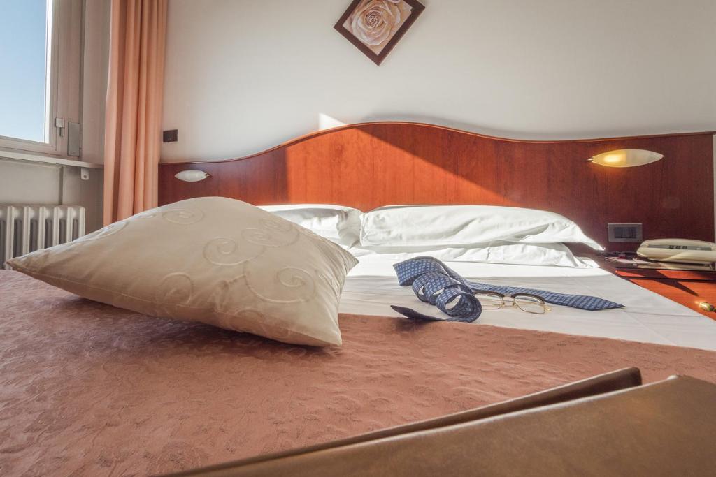 uma cama com duas almofadas em cima em Grifone Hotel Ristorante em Perugia