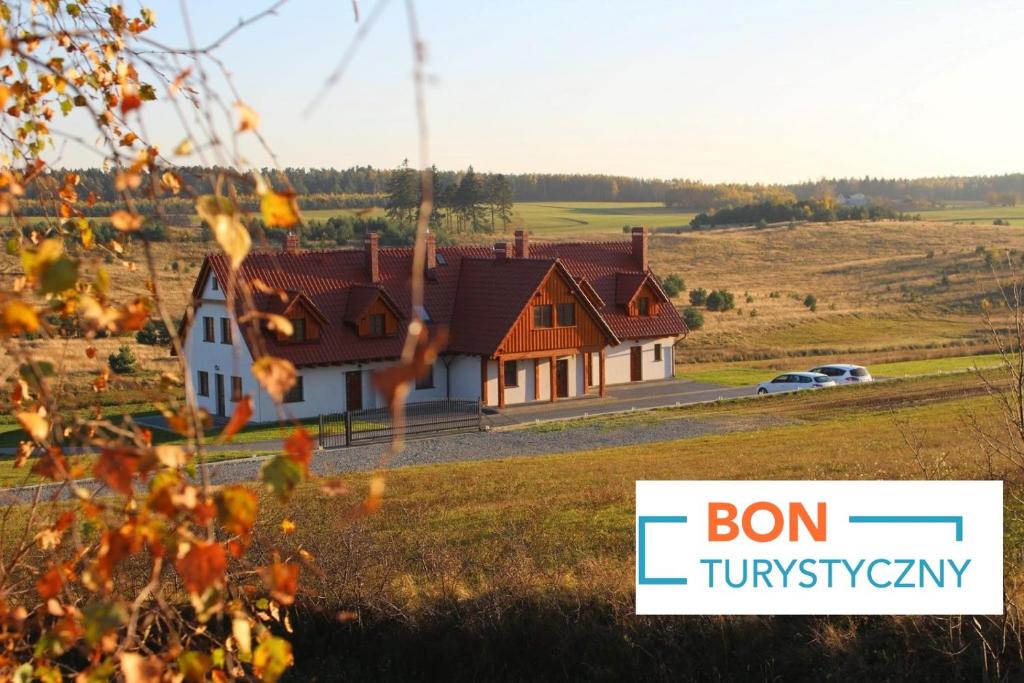 Una casa en un campo con las palabras que nacen cansadas en Apartamenty U Bandurskich, en Sikorzyno