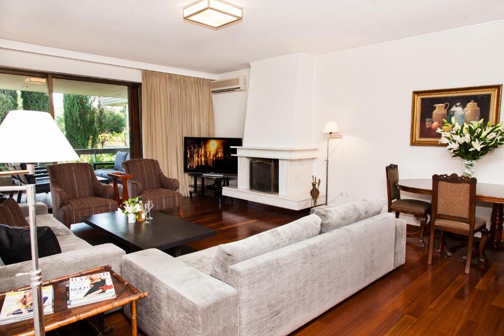 ein Wohnzimmer mit einem Sofa und einem Kamin in der Unterkunft Delux Apartment with Amazing Balcony! in Athen
