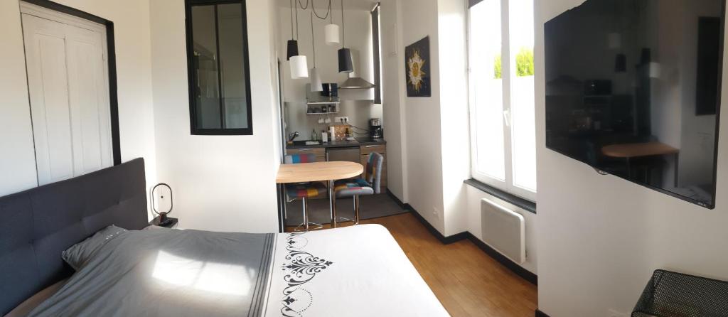 1 dormitorio con 1 cama y 1 mesa en una habitación en Le studio des talents au coeur de Chaumont, en Chaumont