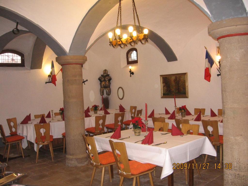 a dining room with tables and chairs with red napkins on them at Alte Poststation Goldener Hirsch in Emskirchen