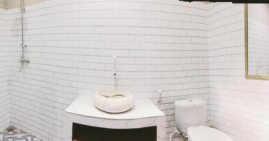 a white bathroom with a sink and a toilet at Villa Pondok Joglo in Yogyakarta
