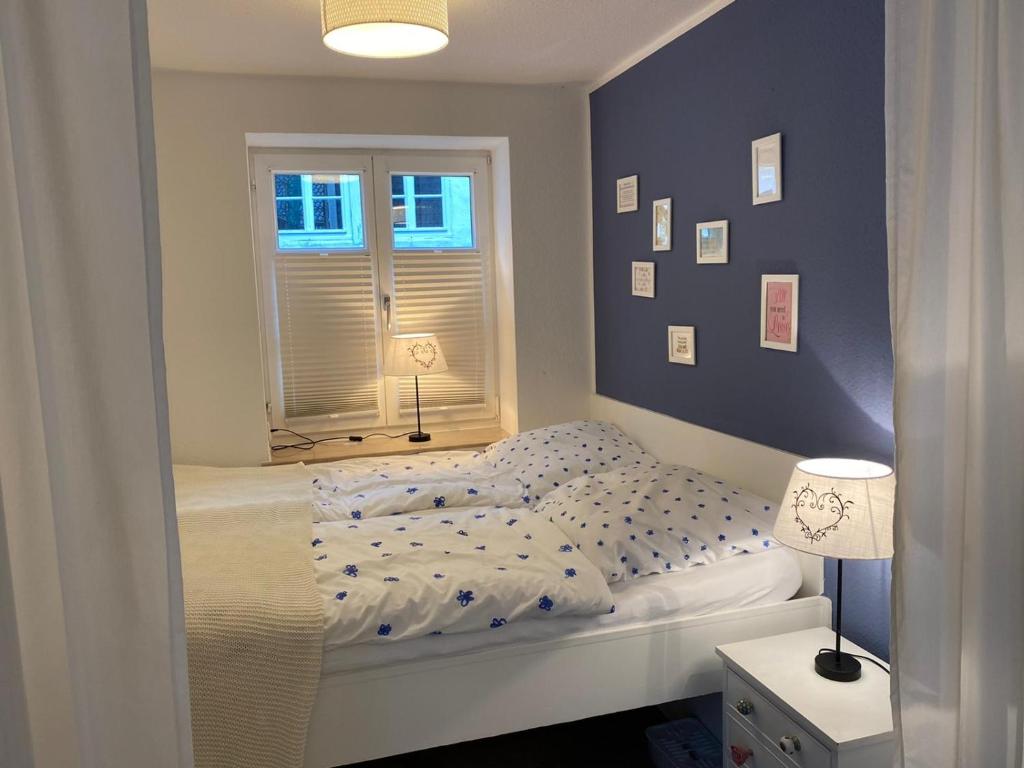 1 dormitorio con cama blanca y ventana en Ferienwohnung Wülfrath en Wülfrath