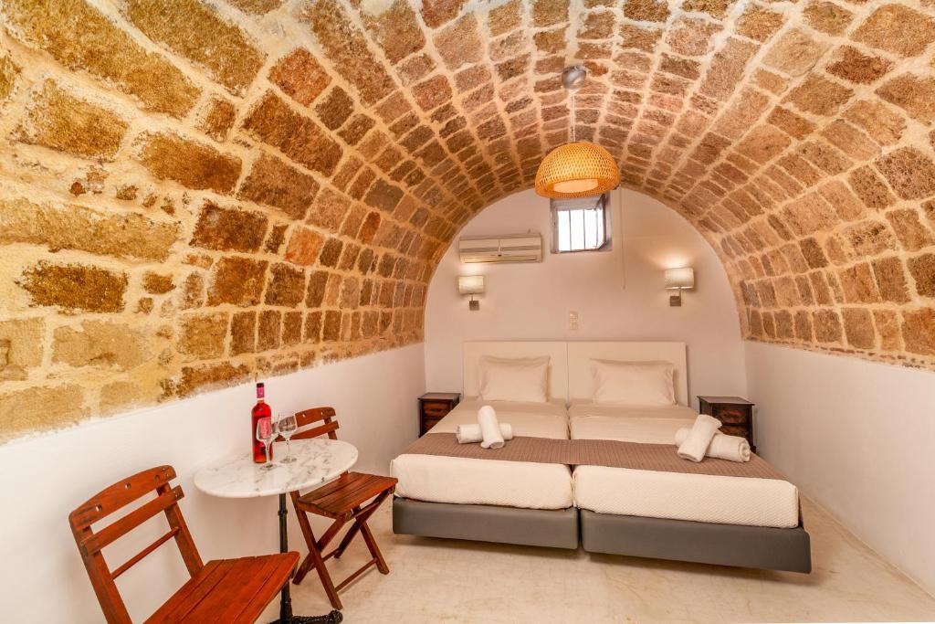 een slaapkamer met een bed in een bakstenen muur bij Auberge 32 Old Town in Rhodos-stad