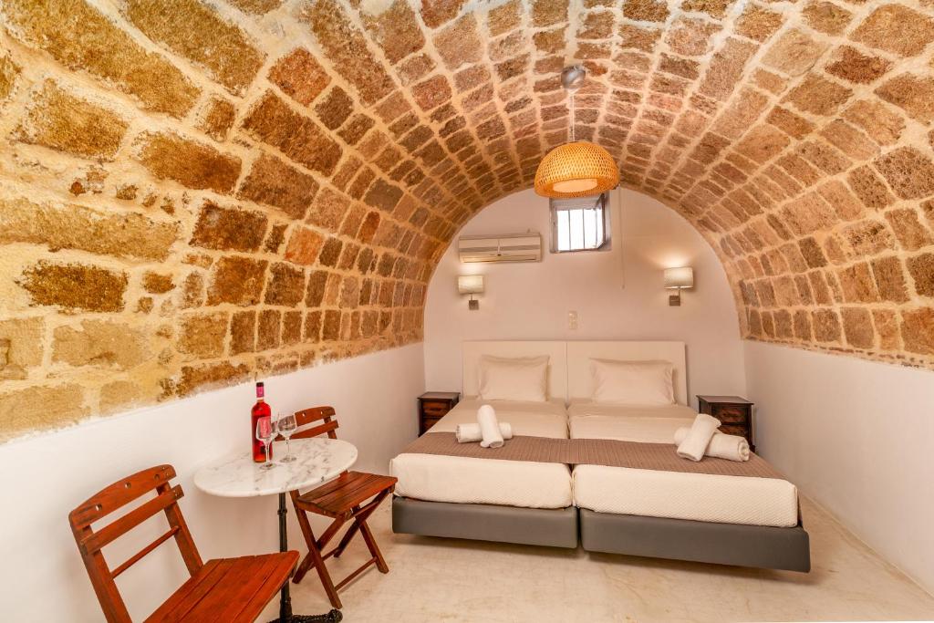 ein Schlafzimmer mit einem Bett in einer Ziegelwand in der Unterkunft Auberge 32 Old Town in Rhodos (Stadt)