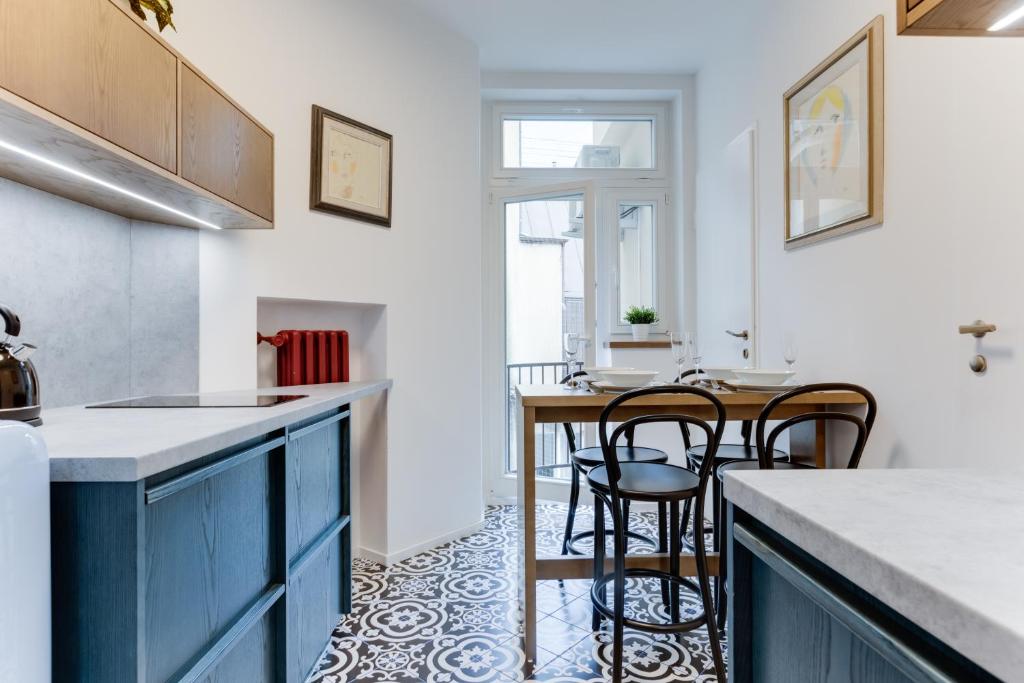 eine Küche mit blauen Schränken und einem Tisch mit Stühlen in der Unterkunft Apartment Petrska in Prag