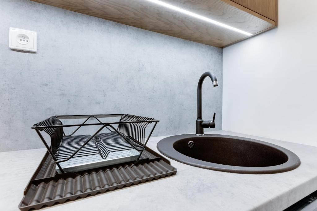 czarny zlew na ladzie z kranem w obiekcie Apartment Petrska w Pradze