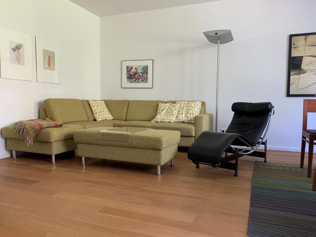 ein Wohnzimmer mit einem Sofa und einem Stuhl in der Unterkunft F80-Die FEINE Ferienwohnung in Regensburg