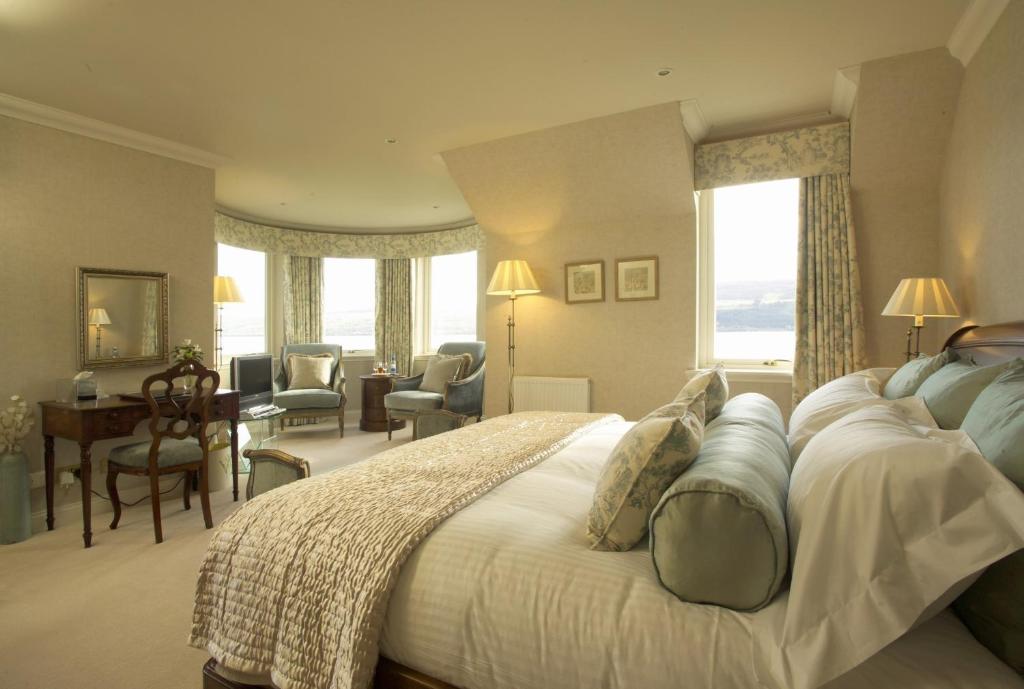
a hotel room with two beds and a table at Loch Ness Lodge in Drumnadrochit
