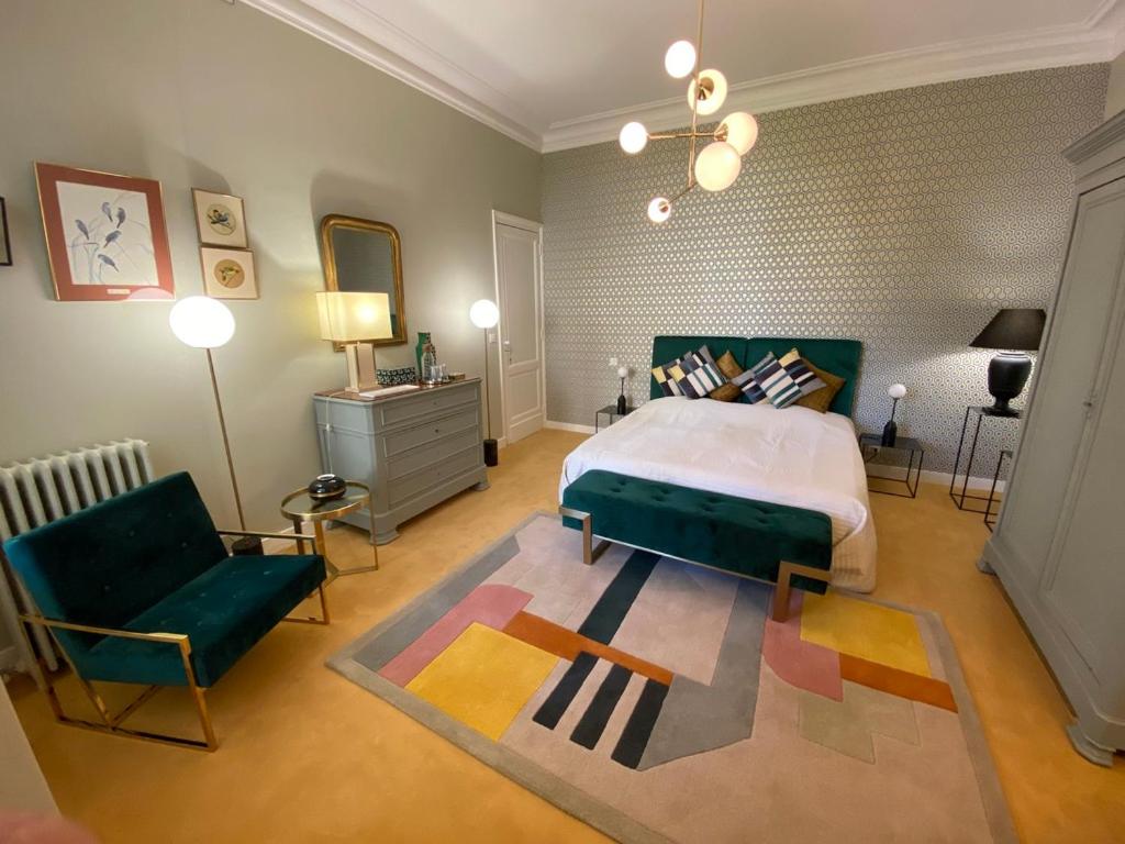 une chambre avec un lit, un canapé et une chaise dans l'établissement La Villa Desvaux de Marigny, à Bordeaux