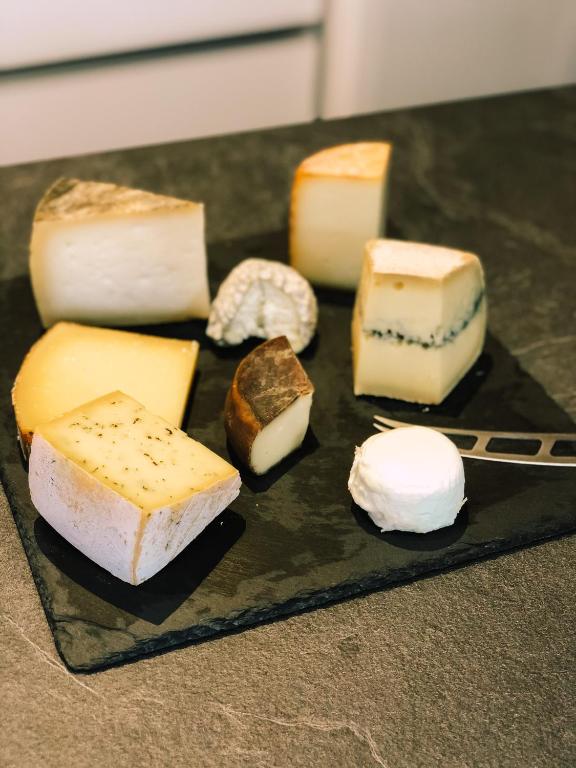 a plate with different types of cheeses on a table at Maison d&#39;hôtes La Rose d&#39;Alsace in Rosheim