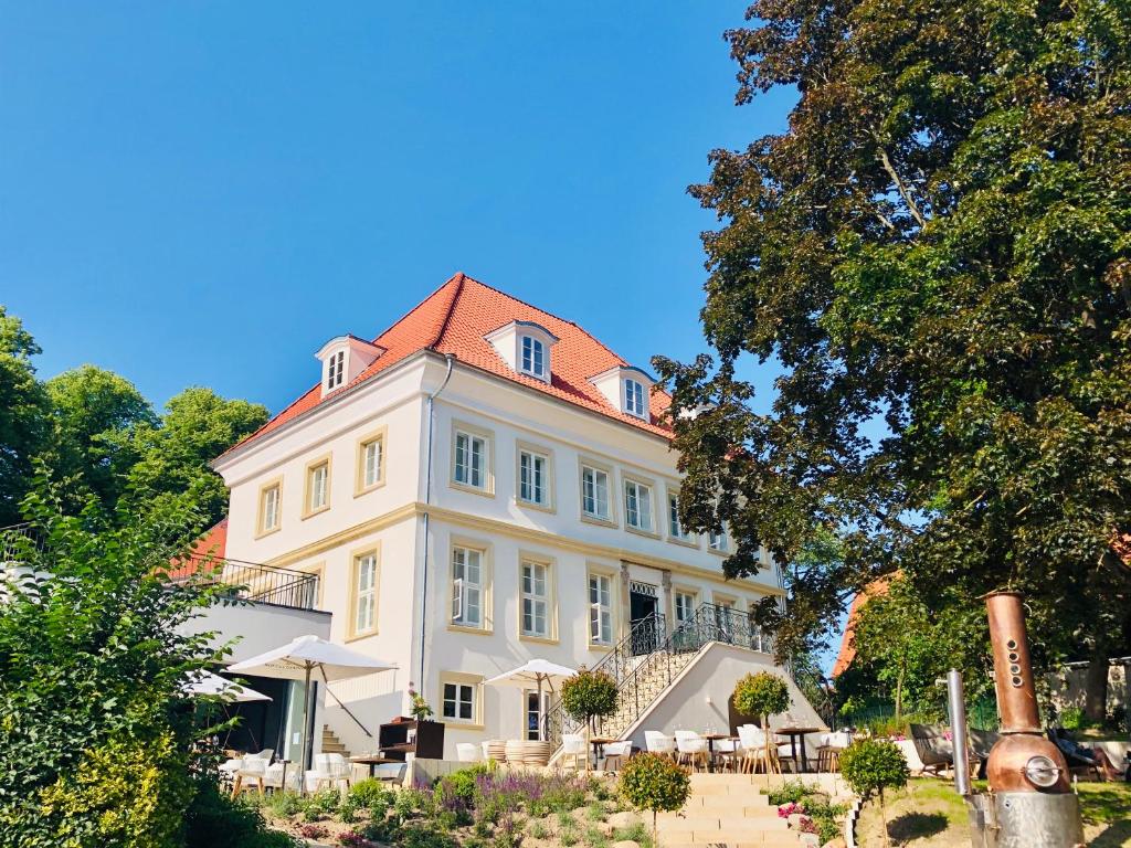 ein großes weißes Gebäude mit rotem Dach in der Unterkunft Wyndberg in Lüneburg