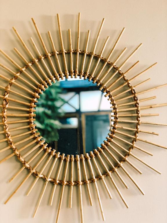 a gold sunburst mirror hanging on a wall at Maison d&#39;hôtes La Rose d&#39;Alsace in Rosheim