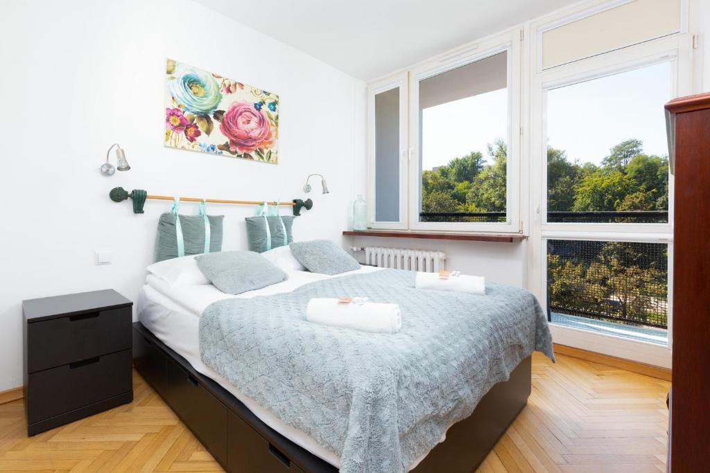 a bedroom with a bed and two windows at Apartments Warsaw Browarna by Renters in Warsaw