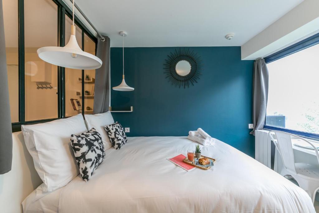 um quarto com uma cama branca e uma parede azul em Apartments WS Tour Eiffel - Nicolo em Paris