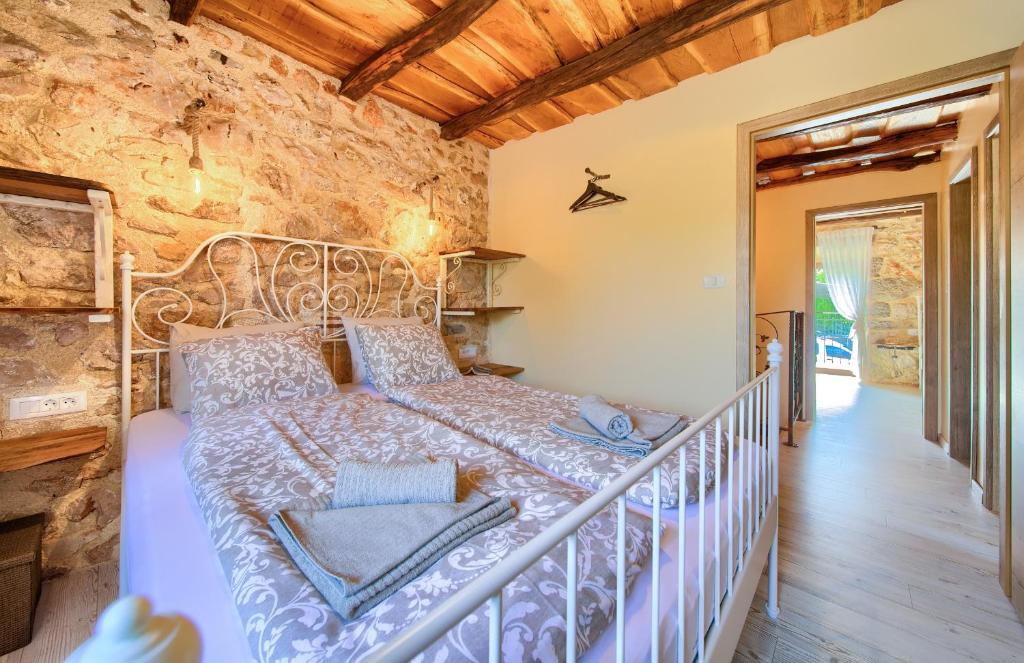 a bedroom with a bed in a stone wall at Holiday House Ursa in Krk