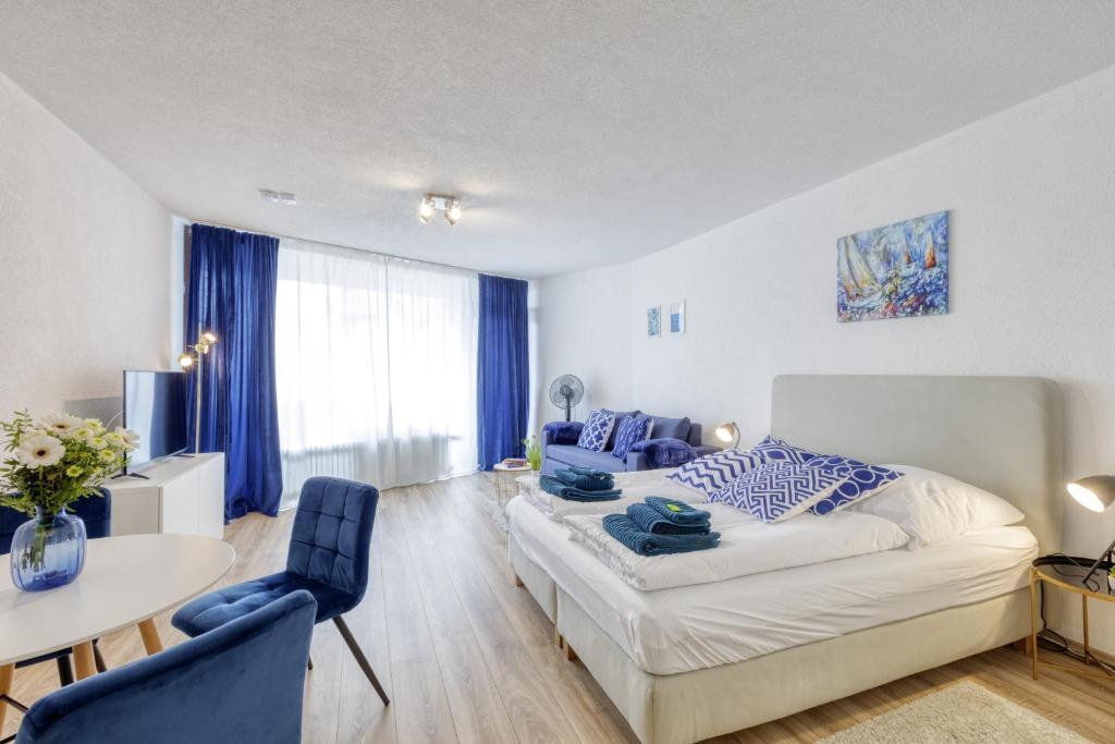 - une chambre avec un lit, une table et des chaises dans l'établissement Relax-Apartment mit Indoor-Pool, Fitness und Netflix am Bodensee, à Uhldingen-Mühlhofen