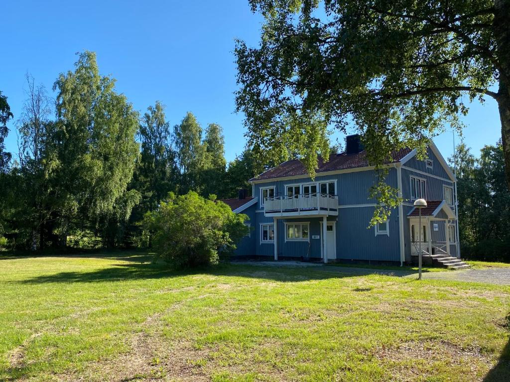 a large blue house with a large yard at Vandrarhemmet Hörneborg in Örnsköldsvik