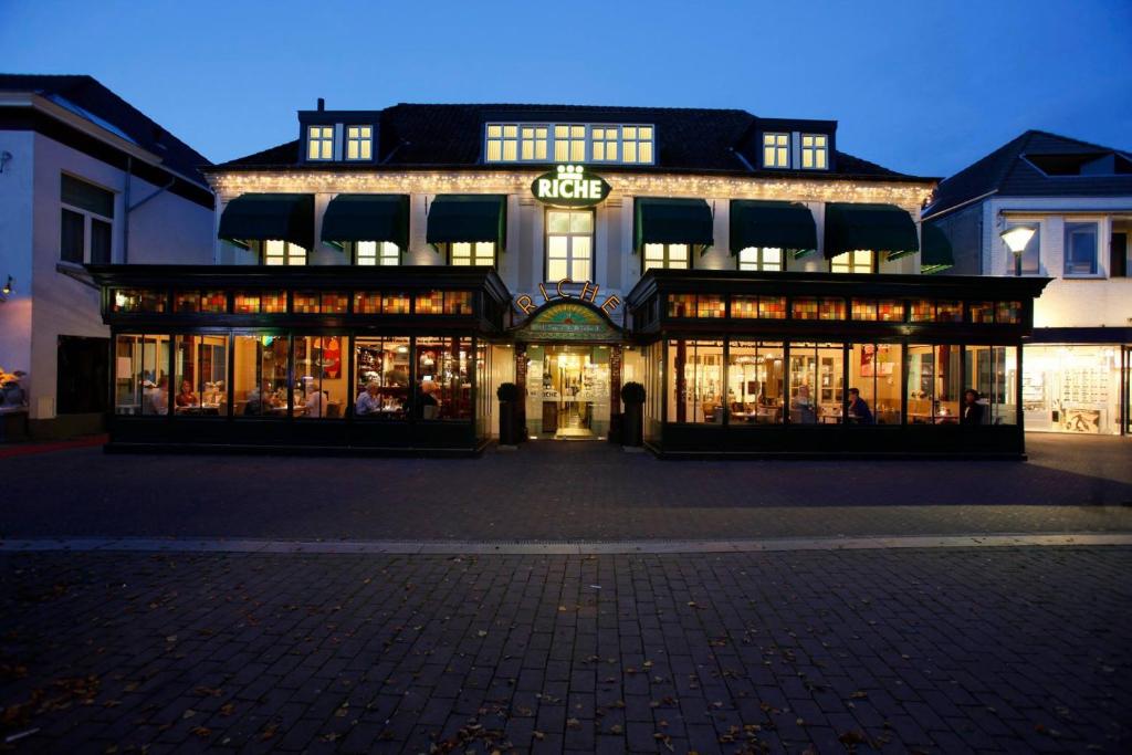 un magasin devant un bâtiment la nuit dans l'établissement Hotel Restaurant Riche, à Boxmeer