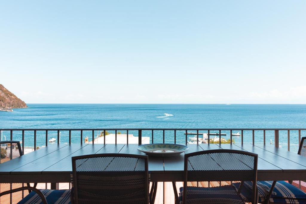 a table on a balcony with a view of the beach at Villa Grazia Lipari in Lipari