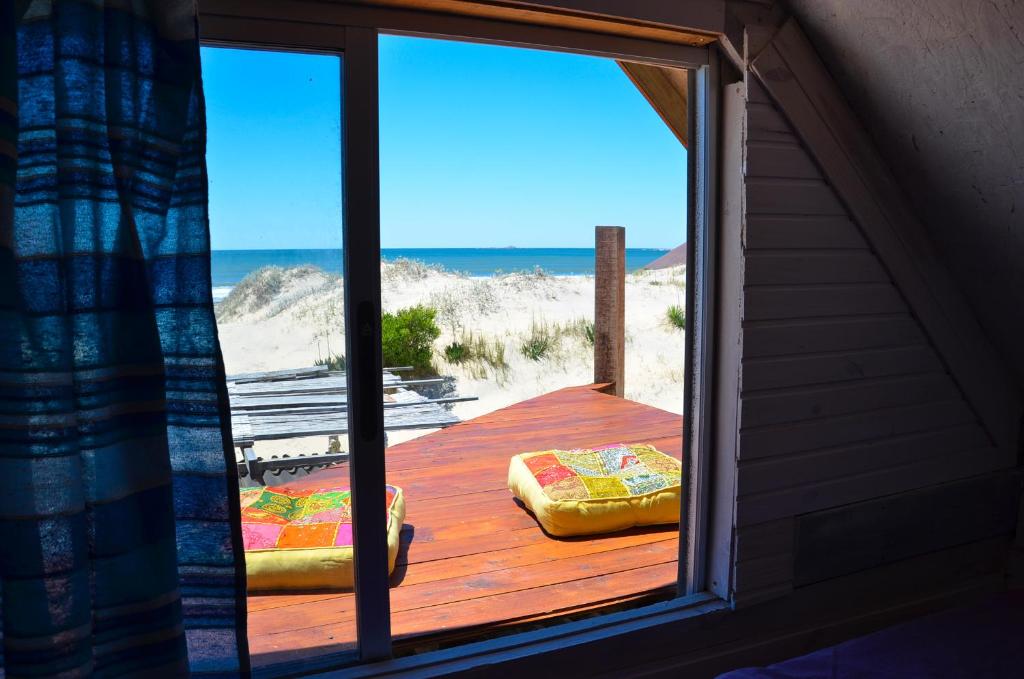 a room with a view of the beach from a window at Solar Valizas in Barra de Valizas