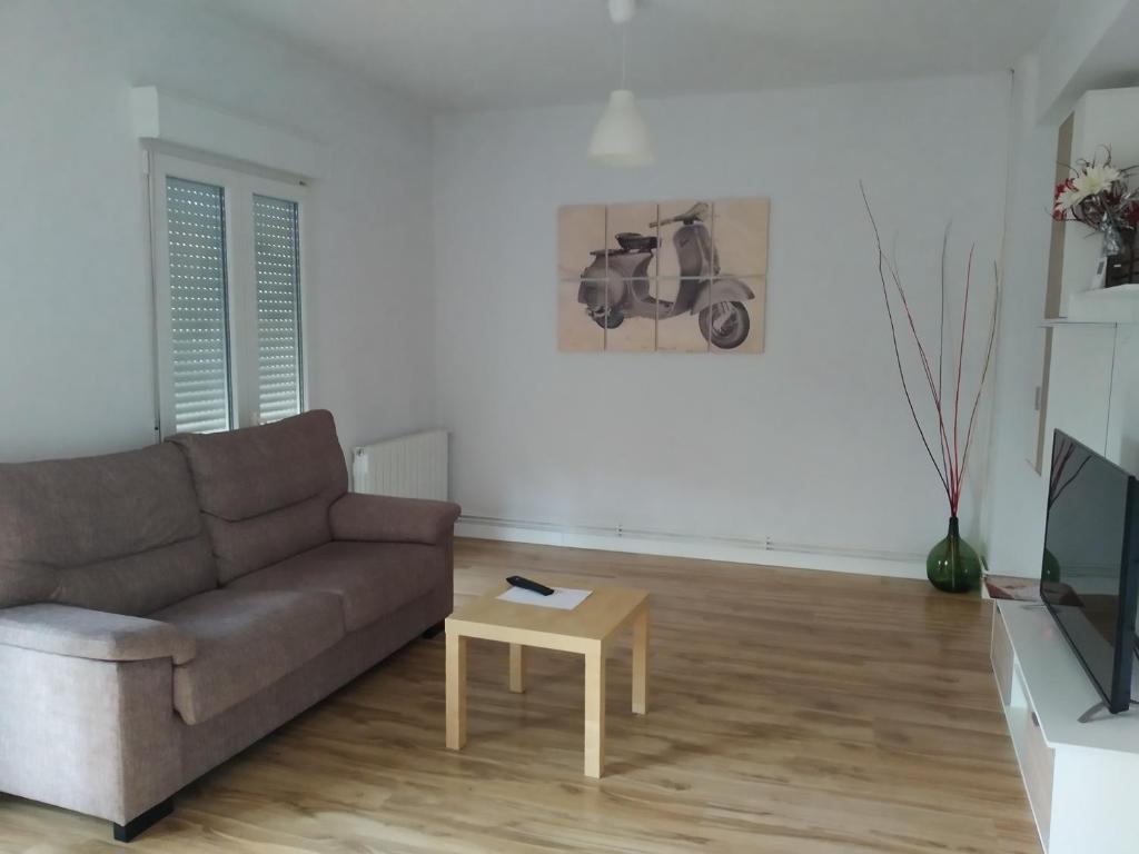 sala de estar con sofá y mesa en Apartamento Mudejar en Teruel