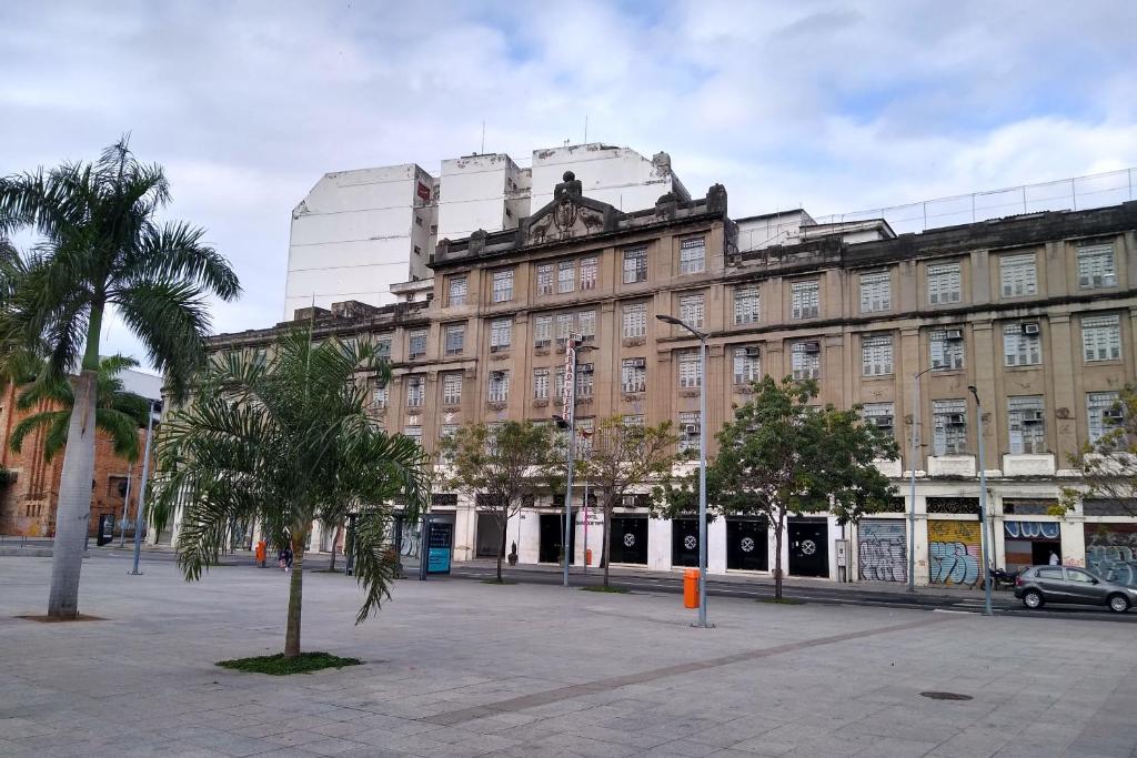 a large building with a palm tree in front of it at Hotel Barão De Tefé in Rio de Janeiro