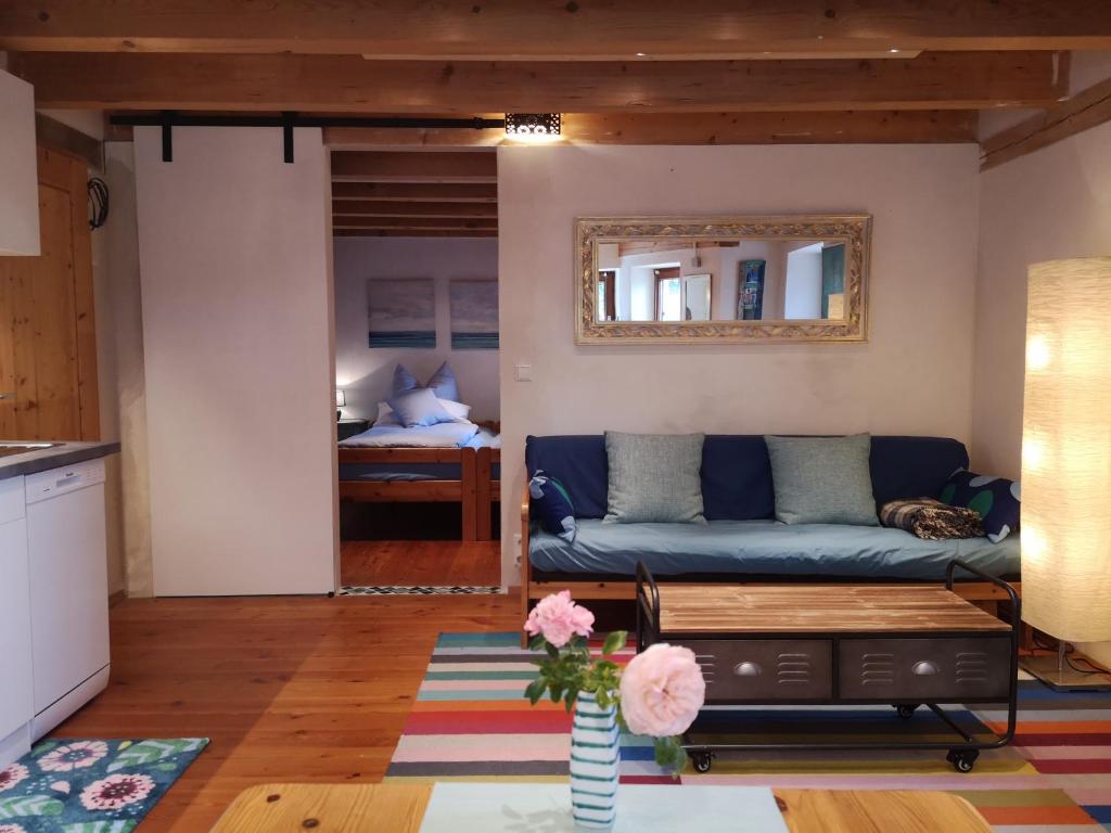 a living room with a blue couch and a bedroom at SEENAH - Ihre Wohnung am Bodensee / Untersee in Gaienhofen